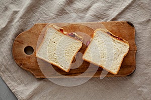 Homemade Peanut Butter and Jelly Sandwich on a rustic wooden board, top view