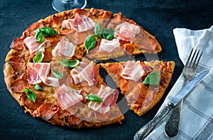 Homemade Pepperoni Pizza with fresh bacon over black background