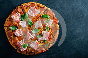 Homemade Pepperoni Pizza with fresh bacon over black background