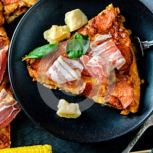 Homemade Pepperoni Pizza with fresh bacon over black background