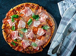 Homemade Pepperoni Pizza with fresh bacon over black background