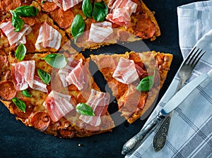 Homemade Pepperoni Pizza with fresh bacon over black background