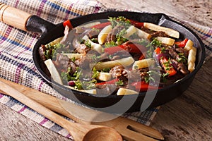 Homemade Peruvian cuisine: lomo saltado in a pan close-up horizontal