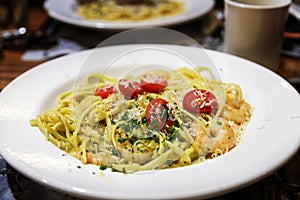 Homemade pesto linguine pasta with sauteed prawns in Alfredo sauce