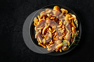 Homemade pickled honey mushrooms on a black stone table