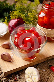 Homemade pickled tomatoes. Bowl of canned tomatoes. Marinated vegetables in a glass jars on background