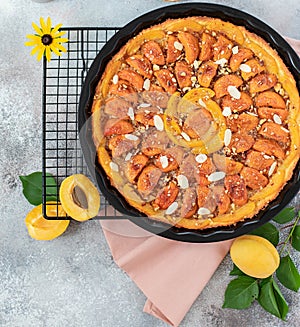 Homemade pie with apricots and nuts on a light background