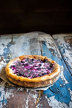 Homemade pie with bilberry on old wooden table.