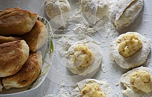 Homemade pie making. Ready, raw pies and filling on the dough.