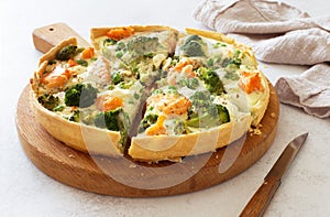 Homemade pie quiche with salmon and broccoli close up