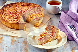 Homemade pie with rhubarb and custard on wooden table