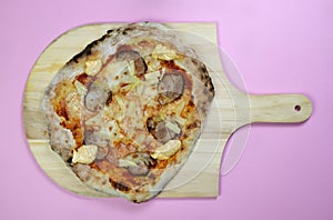 Homemade pizza with pineapple and pork fillet on a wooden board