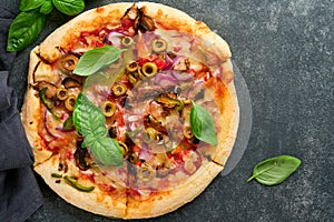 Homemade pizza. Traditional neapolitan pizza with olives, peppers, onions and mushrooms on wooden table backgrounds. Italian