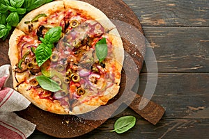 Homemade pizza. Traditional neapolitan pizza with olives, peppers, onions and mushrooms on wooden table backgrounds. Italian