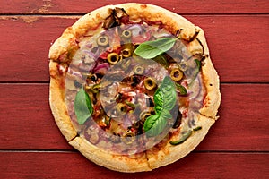Homemade pizza. Traditional neapolitan pizza with olives, peppers, onions and mushrooms on wooden table backgrounds. Italian
