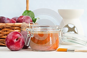 Homemade plum face mask in a glass jar and make-up brush. Natural beauty treatment and spa