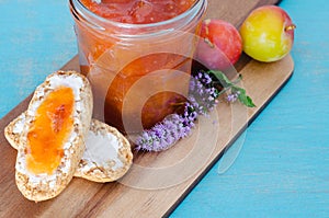 Homemade plum jam. Toasts and plums on wooden board and blue background