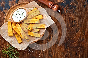 Homemade polenta chips fries with sea salt, parmesan, thyme, rosemary with yogurt sauce. Typical Italian fried polenta. Fried corn