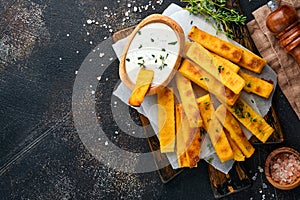 Homemade polenta chips fries with sea salt, parmesan, thyme, rosemary with yogurt sauce. Typical Italian fried polenta. Fried corn