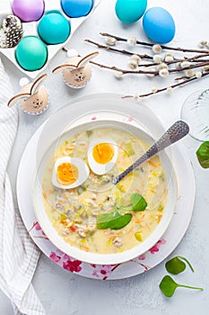 Homemade polish Easter soup with addition of sausage, hard boiled egg and vegetables in a bowl