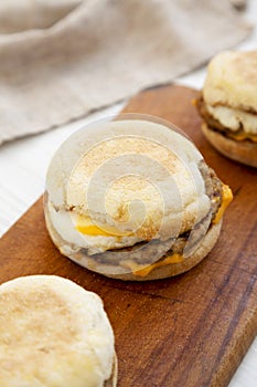 Homemade pork roll egg sandwich on a rustic wooden board on a white wooden background, low angle view. Closeup