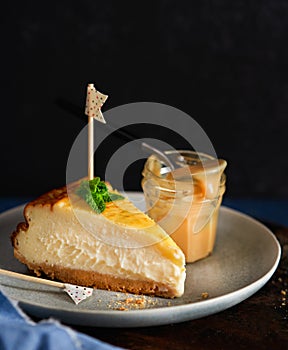 Homemade portion Basque burnt creamy cheesecake, New York style Cheesecake with Dulce de leche or manjar, dark background, photo