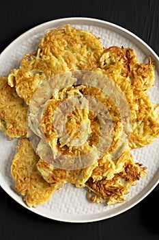 Homemade Potato Pancakes Latkes with Apple Sauce and Sour Cream on a black wooden surface, top view. Flat lay, overhead, from