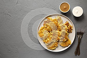 Homemade Potato Pancakes Latkes with Apple Sauce and Sour Cream on a gray background, top view. Flat lay, overhead, from above.