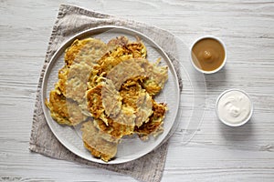 Homemade Potato Pancakes Latkes with Apple Sauce and Sour Cream on a white wooden background, top view. Flat lay, overhead, from