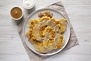 Homemade Potato Pancakes Latkes with Apple Sauce and Sour Cream on a white wooden table, top view. Flat lay, overhead, from above