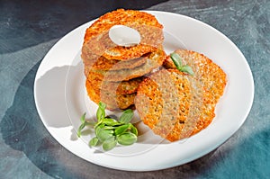 Homemade potato pancakes, latkes, draniki, hash browns or fritters served with sour cream and sunflower sprouts. Closeup