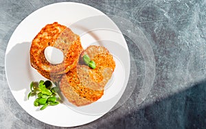 Homemade potato pancakes, latkes, draniki, hash browns, fritters with sour cream and sunflower sprouts. Copy space