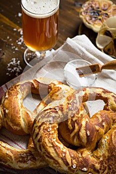 Homemade Pretzel with Sea Salt and Glass of Beer on Rustic Wooden Table