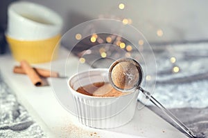 Homemade pudding with cinnamon sticks on a white background, close up