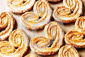 Homemade puff pastries in the shape of a heart on wooden background