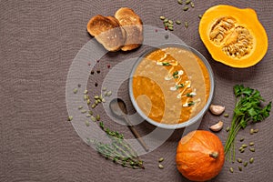 Homemade pumpkin cream soup in a bowl. Cozy thanksgiving dinner. View from above