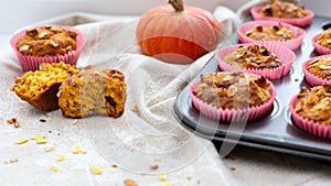 Homemade pumpkin muffins with pumpkin seeds and walnut pieces. Fall baking for Thanksgiving and Halloween. Cupcakes in baking dish