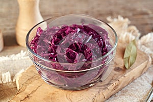 Purple fermented cabbage or sauerkraut in a transparent glass bowl