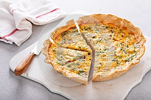 Homemade quiche with ham and cheese cut on the table