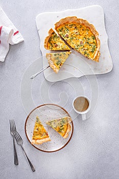 Homemade quiche with ham and cheese cut on the table