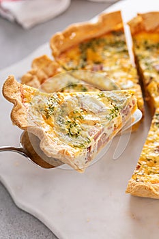 Homemade quiche with ham and cheese cut on the table