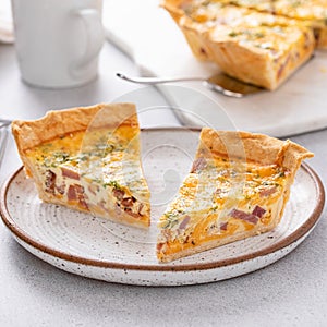 Homemade quiche with ham and cheese cut on the table