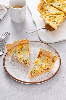 Homemade quiche with ham and cheese cut on the table