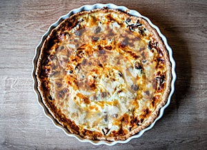 Homemade quiche pie with mushrooms (champignons) and cheese on the table. Savory tart pie with mushrooms