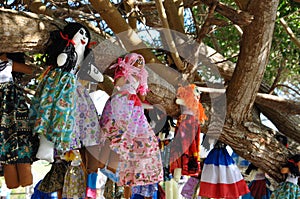 Homemade rag dolls are hanging on the tree photo