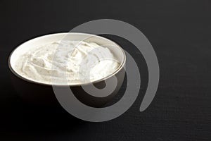 Homemade Ranch Dressing in a Bowl on a black background, side view. Space for text