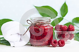 Homemade raspberry face and body mask/scrub in a glass jar. DIY cosmetics and spa.