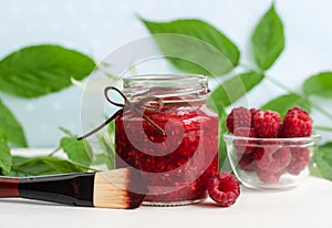 Homemade raspberry facial mask exfoliating face and body sugar scrub in the glass jar. Fruit DIY beauty treatment and spa recipe