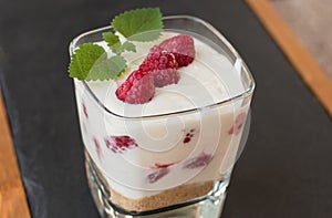 Homemade Raspberry fruit yogurt with fresh green mint leaf on glass cup.