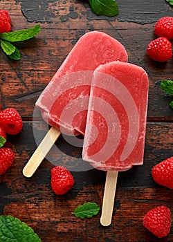 Homemade raspberry popsicles, ice lolly on wooden table. background. Summer food